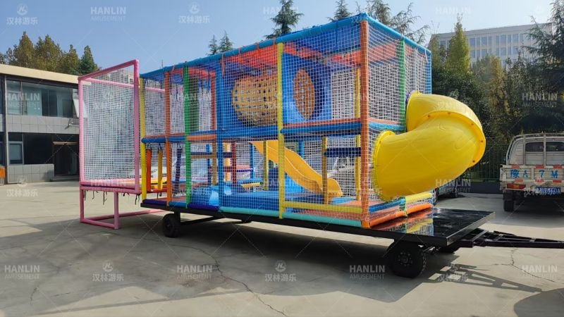 Side View Of Trailer Mounted Playground With Yellow Spiral Slide