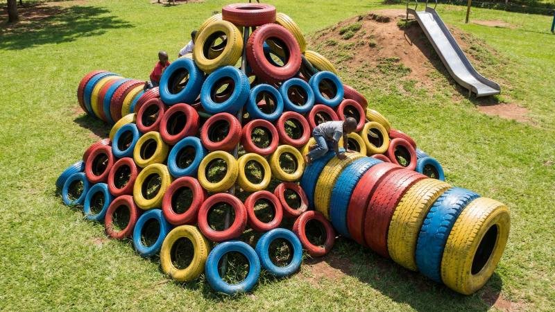 Colorful Upcycled Tire Climbing Structure On Grass