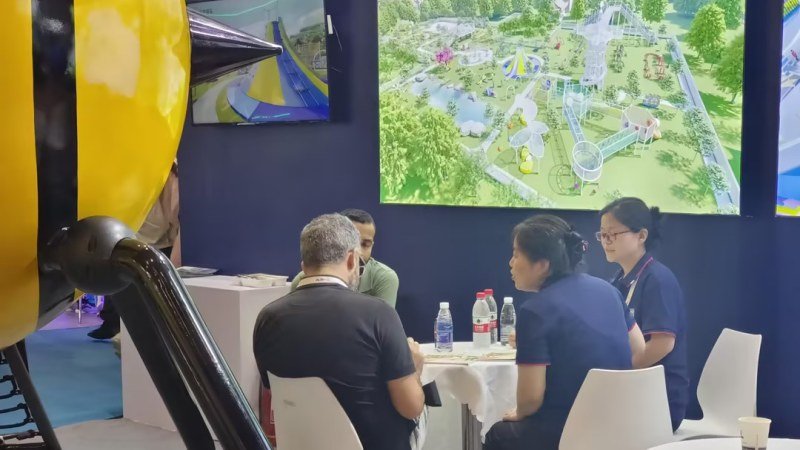 Hanlin Amusement sales team discussing custom playground project with clients at Beijing Expo 2023