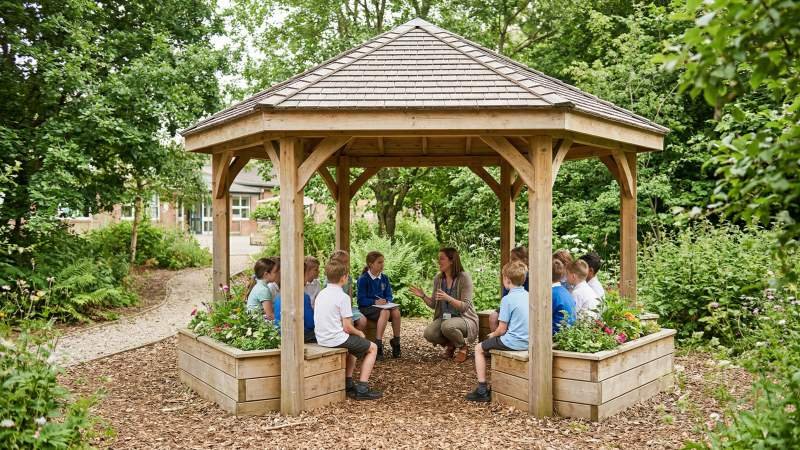 Students Learning In Wooden Outdoor Classroom Gazebo