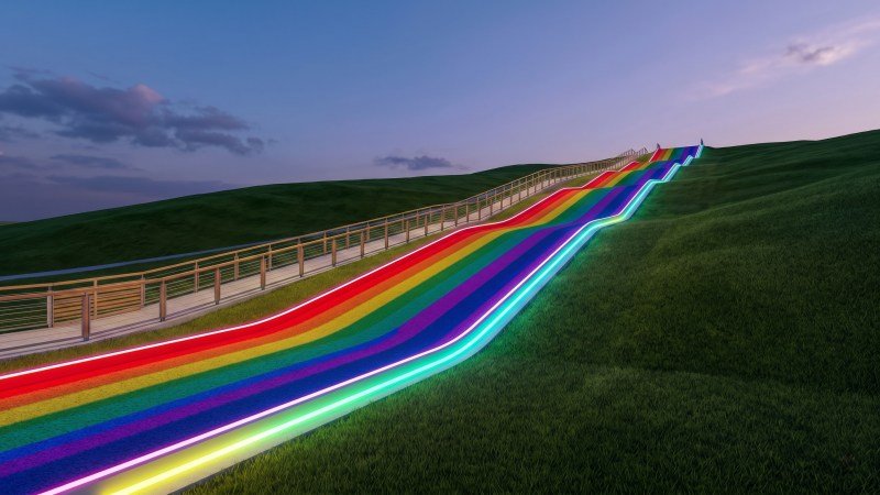 Illuminated Rainbow Slide On Hillside At Dusk